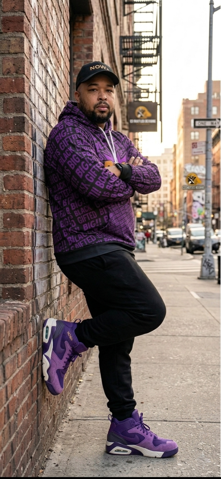 Elisha Carter, founder of EC Hustles, leaning against a brick wall wearing a purple BIG!! hoodie and purple Nikes